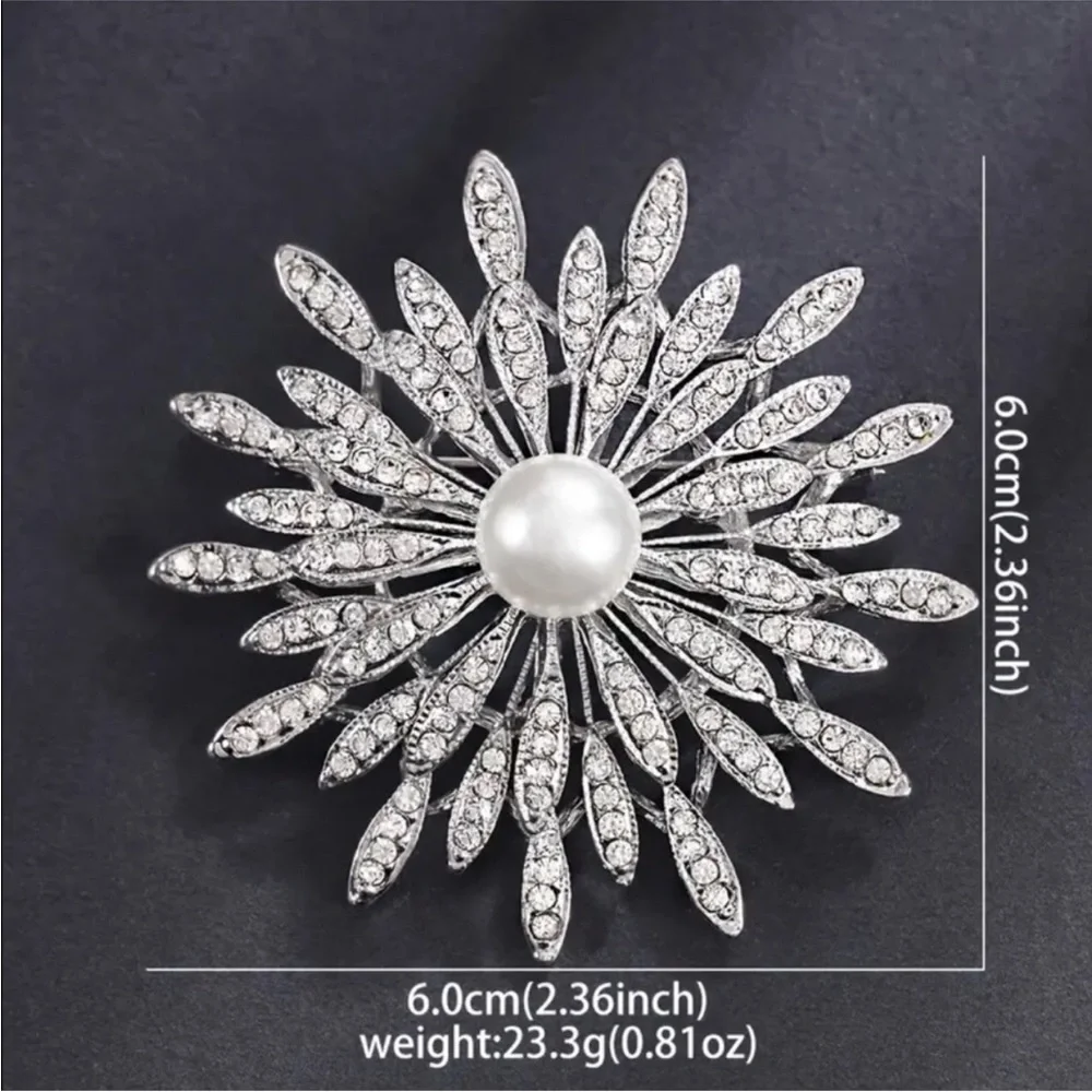 New silver-toned sunburst brooch clear rhinestones and a central faux pearl